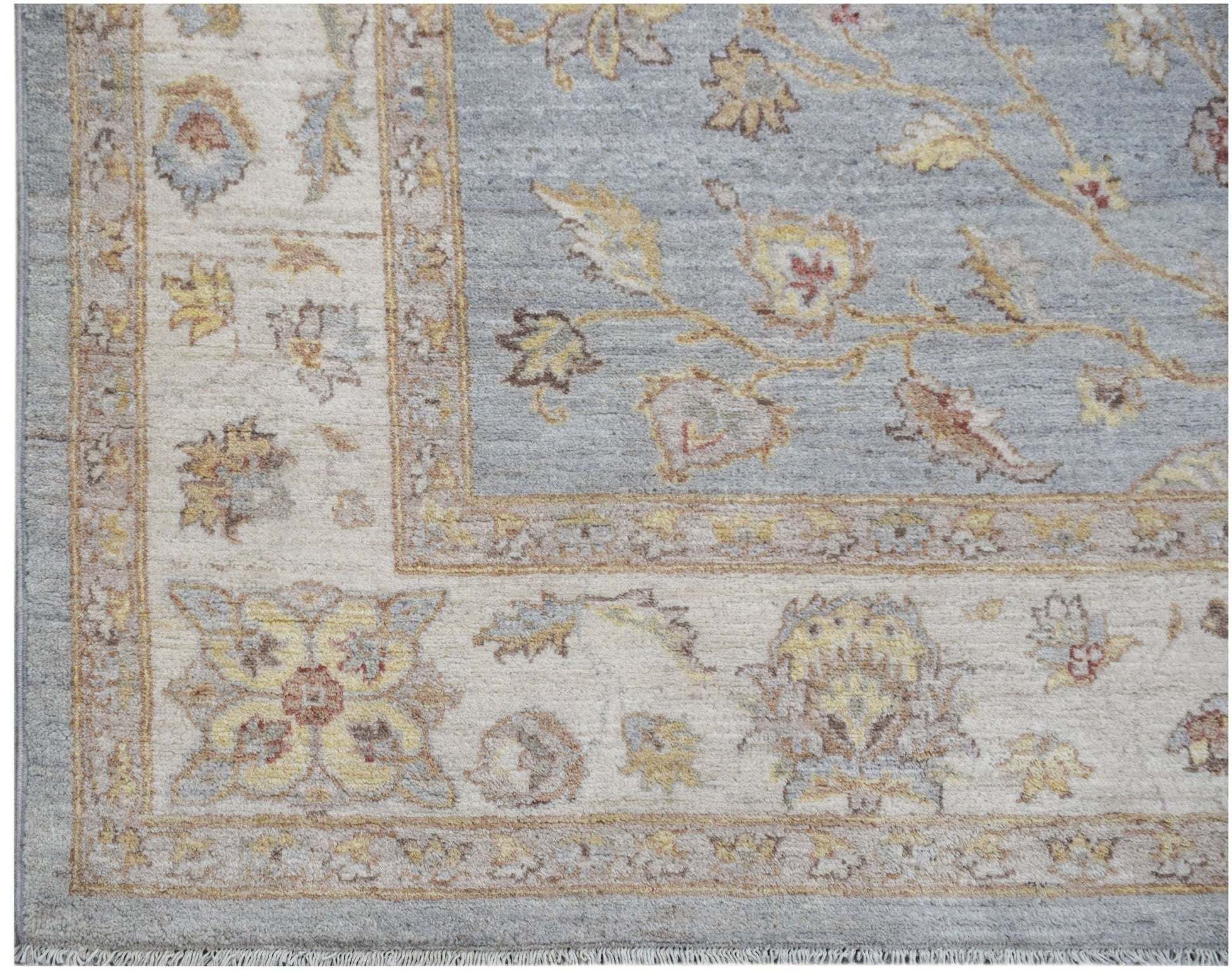 A handmade Afghan Chobi rug featuring a blue field with floral patterns and a cream border.