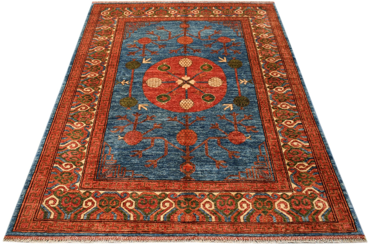 A rectangular Afghan Chobi rug featuring a central red medallion on a blue field with floral motifs.