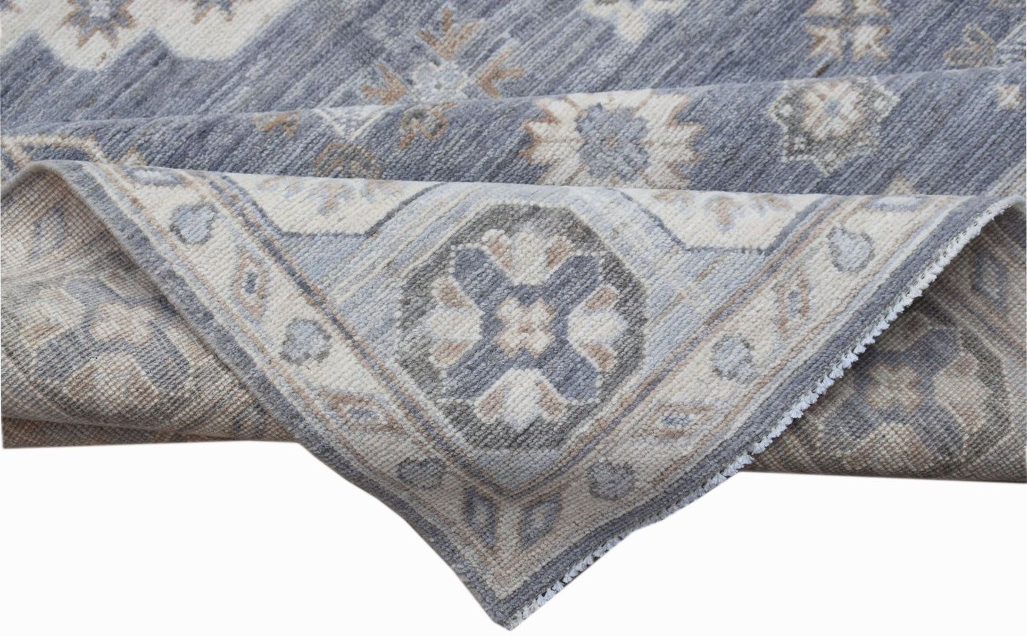 A handwoven Afghan Chobi rug featuring a traditional geometric pattern in shades of blue and beige.