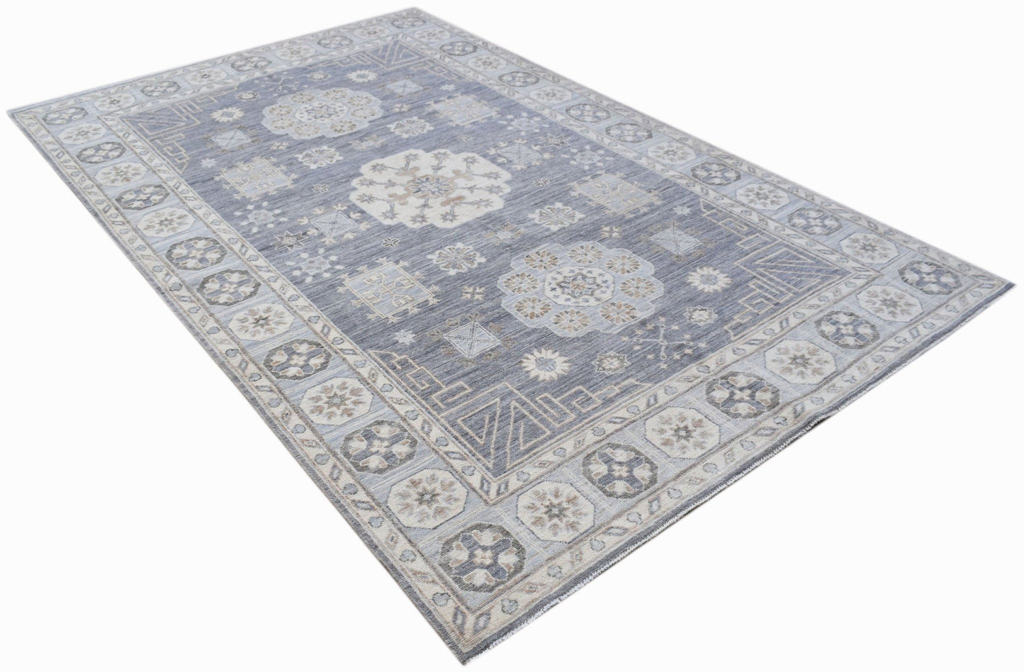 A rectangular Afghan Chobi rug featuring a traditional floral pattern in shades of blue and beige.