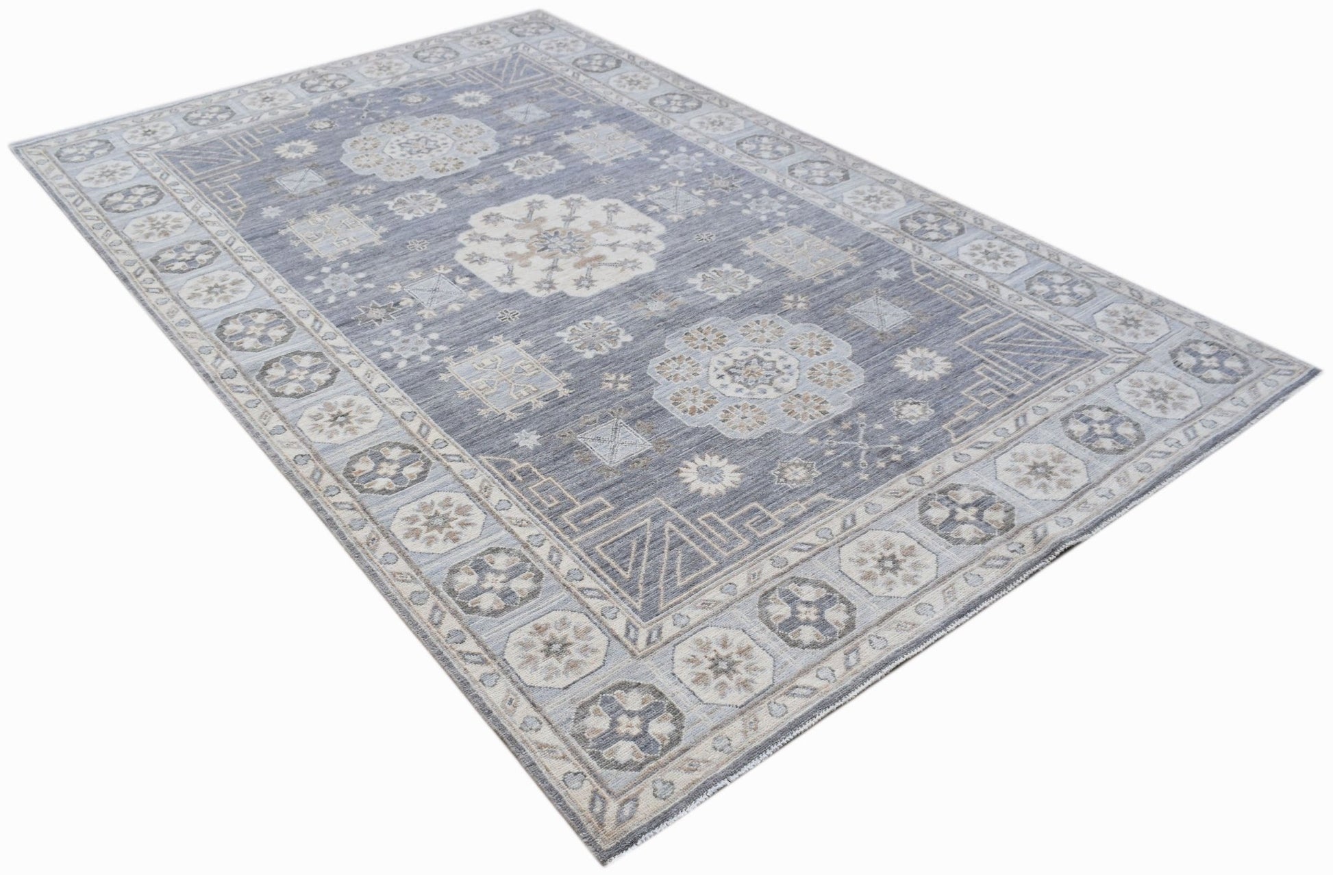 A rectangular Afghan Chobi rug featuring a traditional floral pattern in shades of blue and beige.