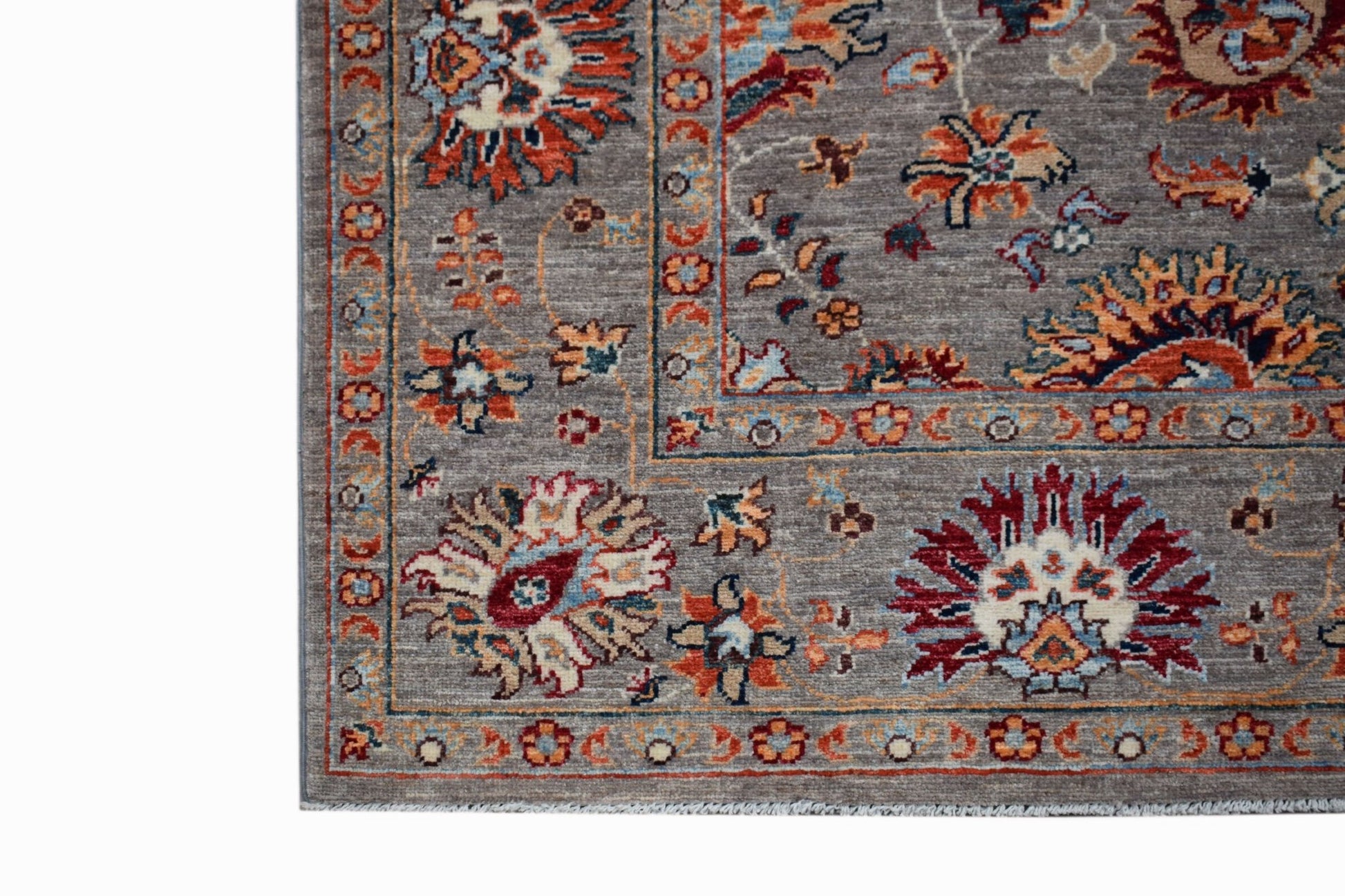 A handwoven Afghan Chobi rug featuring a traditional floral pattern in earthy tones on a grey base.