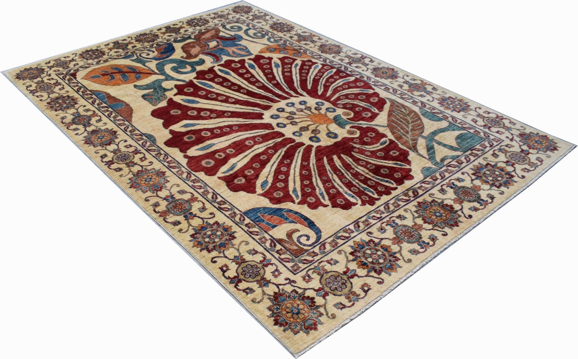 A handmade Afghan Chobi rug featuring a large central floral motif on a cream background.