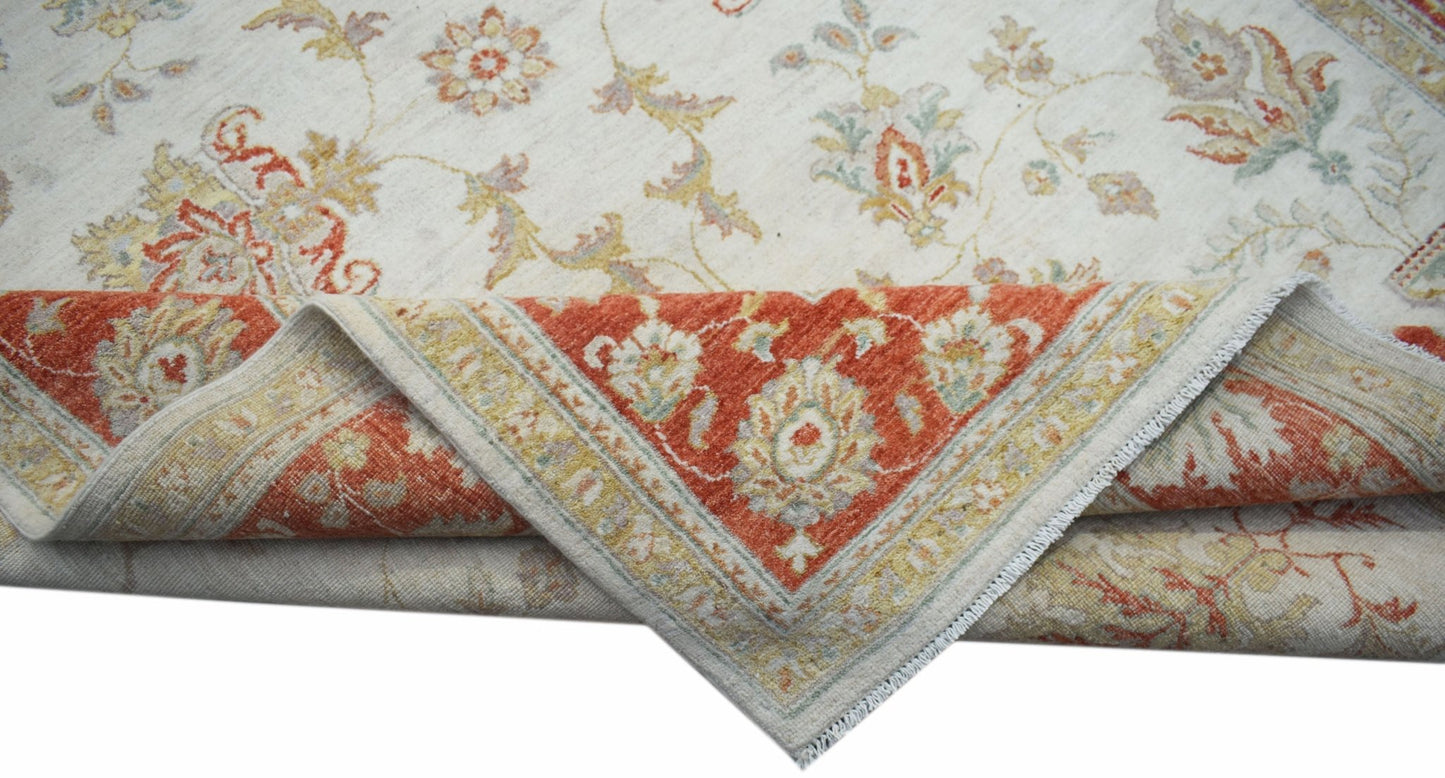 A handmade Afghan Chobi rug featuring a cream field with floral motifs and a rust-colored border.