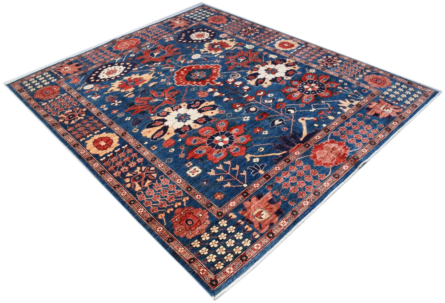 A rectangular Afghan Chobi rug featuring a traditional floral pattern in red and blue tones.