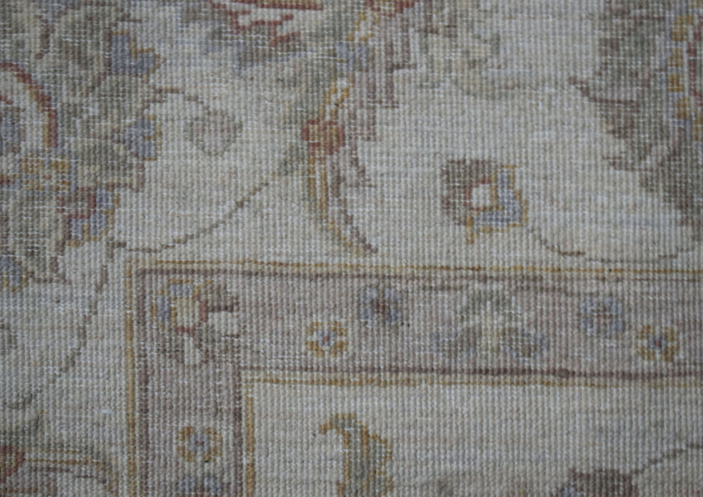 A close-up of a handwoven Afghan Chobi rug featuring traditional floral patterns in muted tones.
