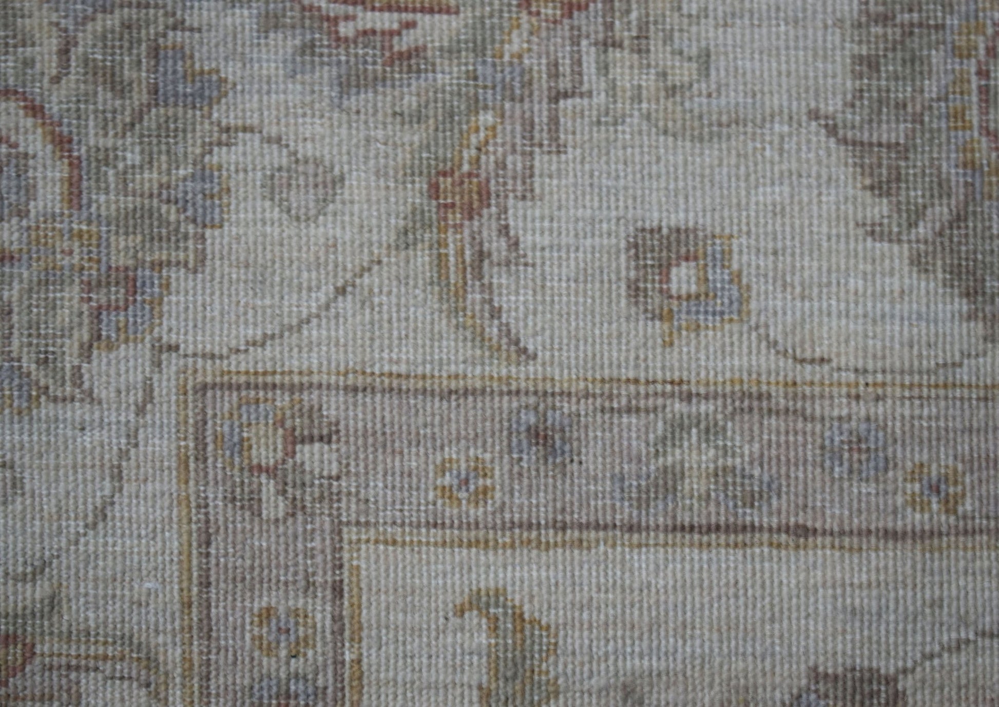 A close-up of a handwoven Afghan Chobi rug featuring traditional floral patterns in muted tones.