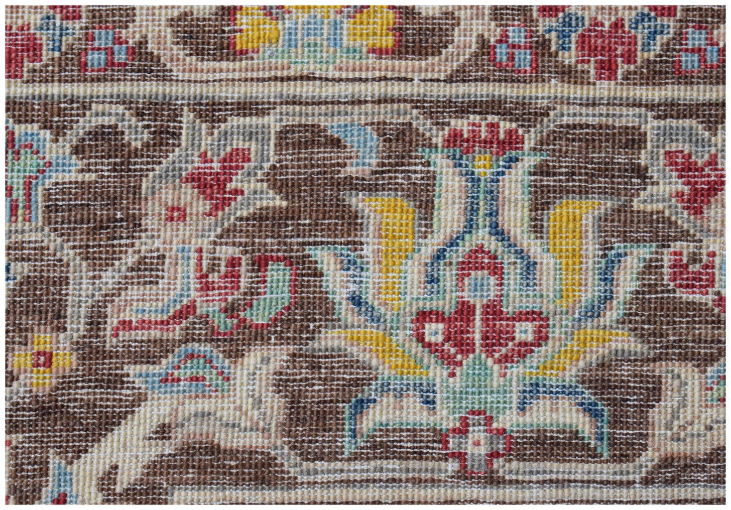 A close-up of an Afghan Chobi rug featuring intricate floral patterns in earthy tones.