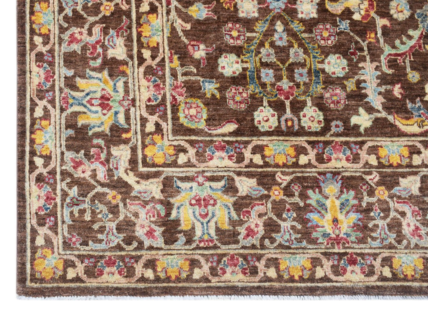 Handwoven Afghan Chobi rug featuring a traditional floral pattern in earthy tones on a brown base.