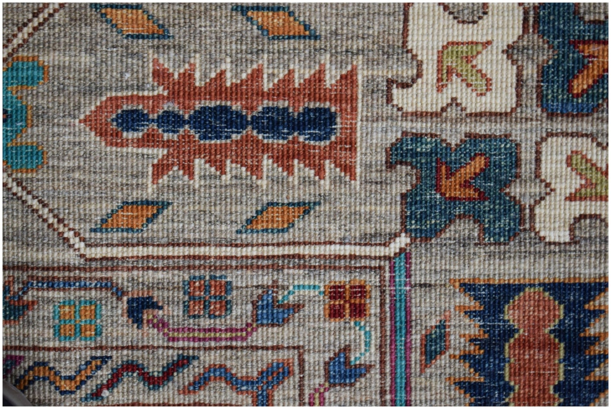 A close-up of an Afghan Chobi rug featuring intricate geometric patterns in earthy tones.