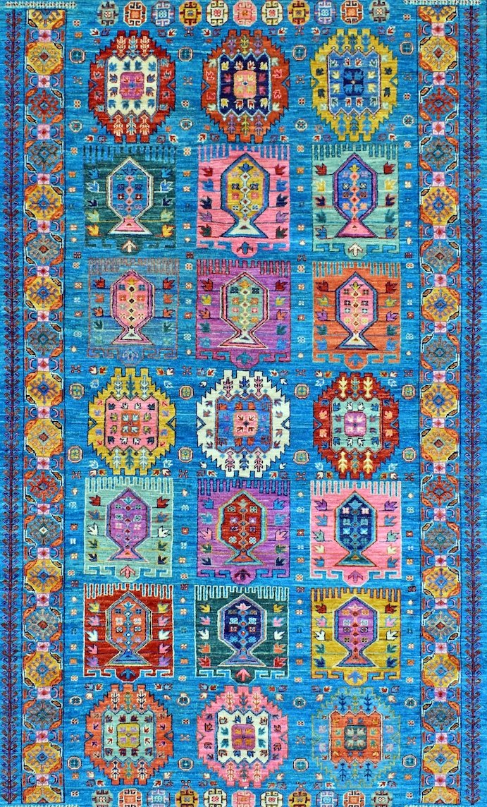 An Afghan Chobi rug featuring a vibrant blue field with repeating geometric and floral motifs.