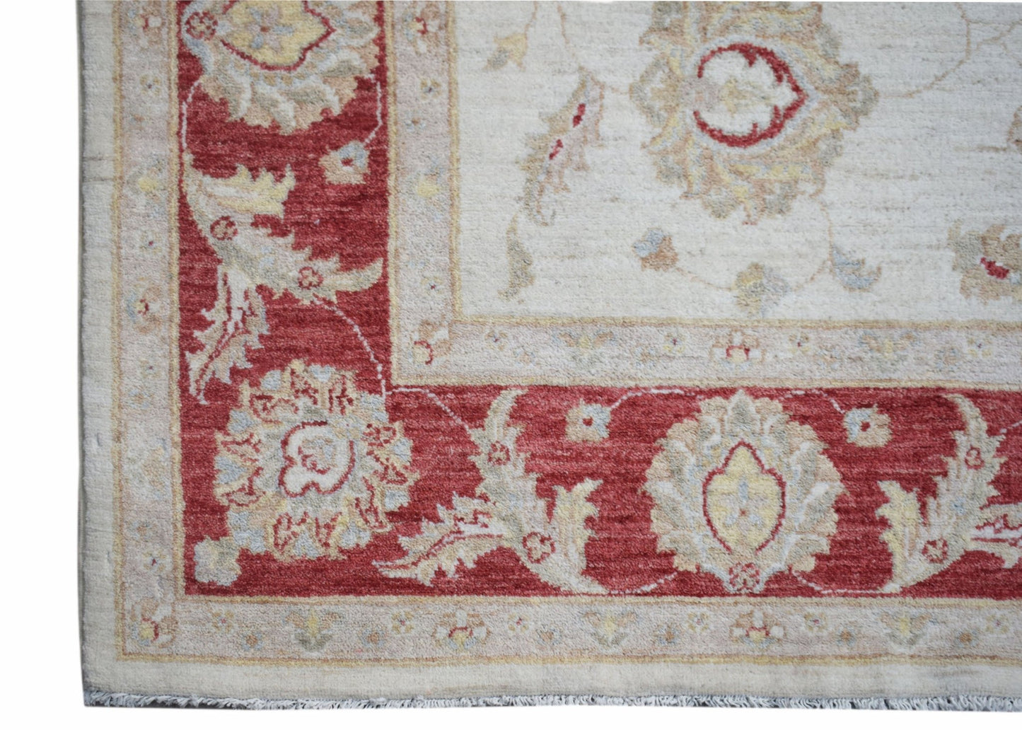 A handmade Afghan Chobi rug featuring a traditional floral pattern in red and cream tones.