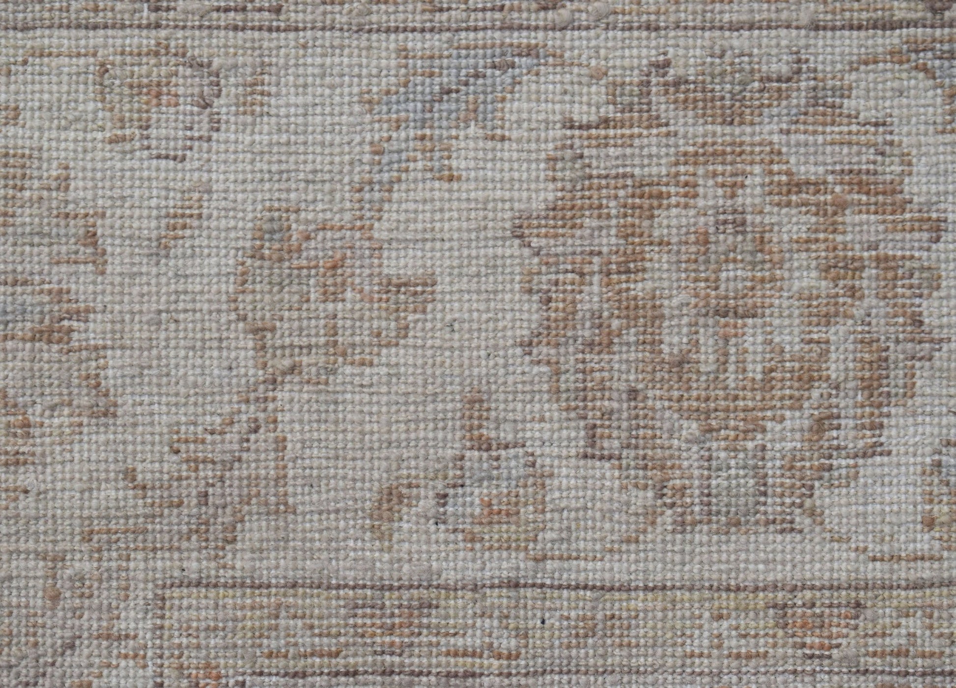 A close-up of a handwoven Afghan Chobi rug featuring a traditional floral pattern in neutral tones.