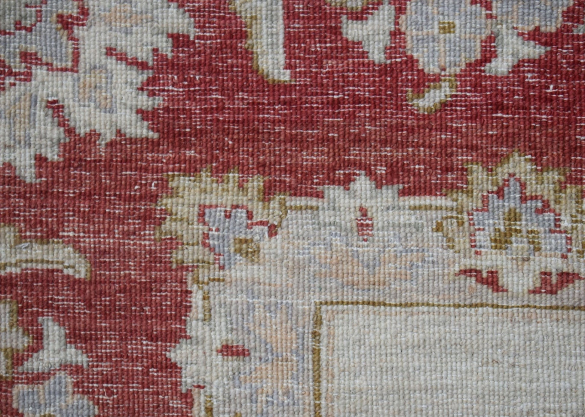 A close-up of a handwoven Afghan Chobi rug featuring intricate floral patterns in red and beige.
