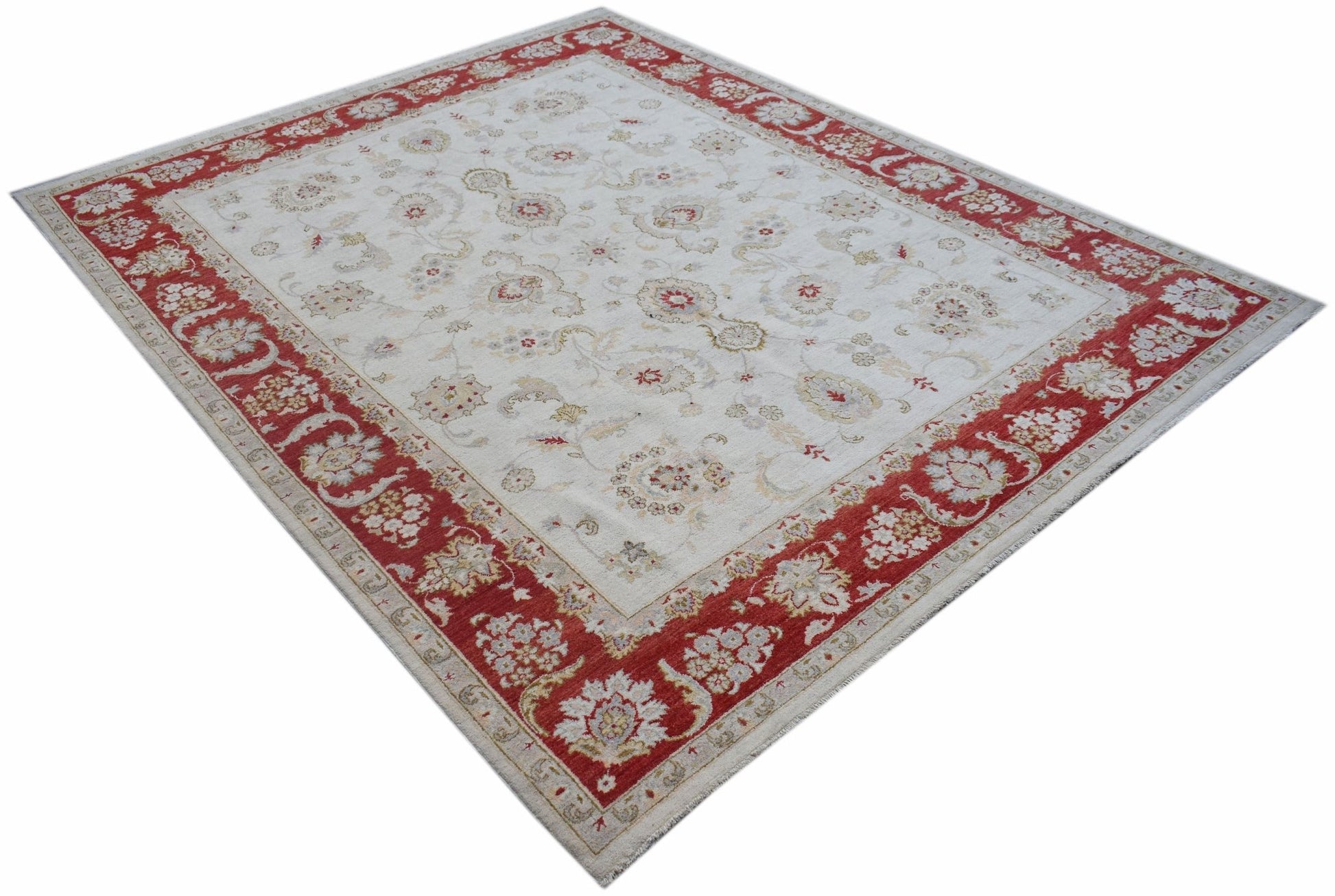 An Afghan Chobi rug featuring a cream field with floral motifs and a wide red border.