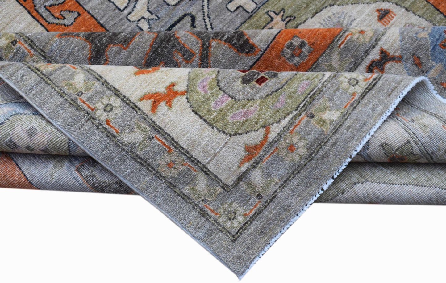 A folded Afghan Chobi rug featuring traditional patterns in shades of grey, orange, and green.