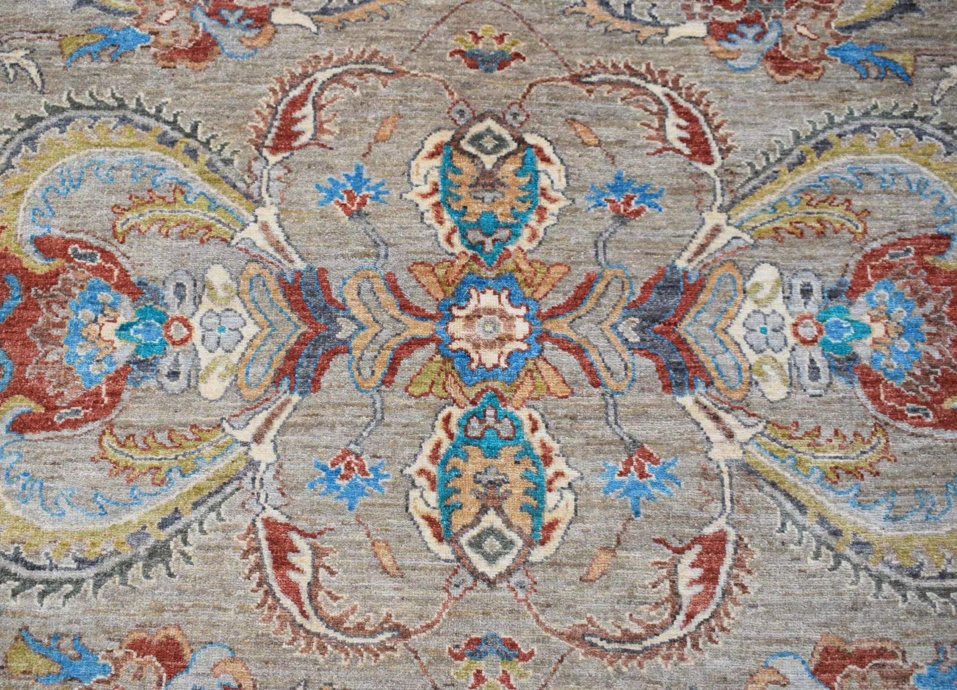 A handwoven Afghan Chobi rug featuring a traditional floral medallion pattern in earthy tones.