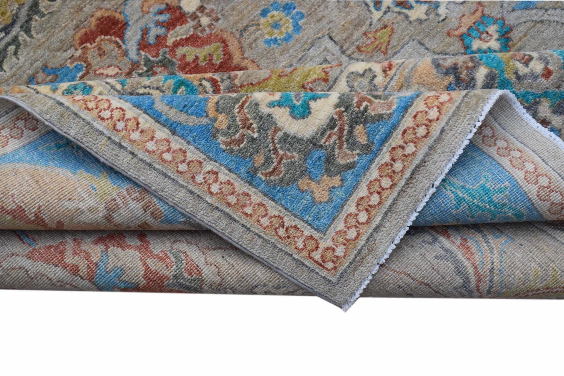 A folded Afghan Chobi rug featuring intricate floral patterns in blue, red, and earthy tones.
