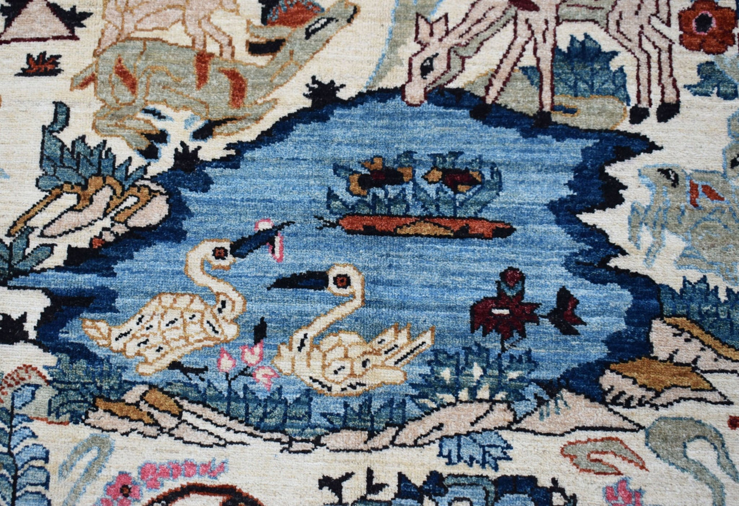 A handwoven Afghan Chobi rug featuring a detailed hunting scene with animals and birds.