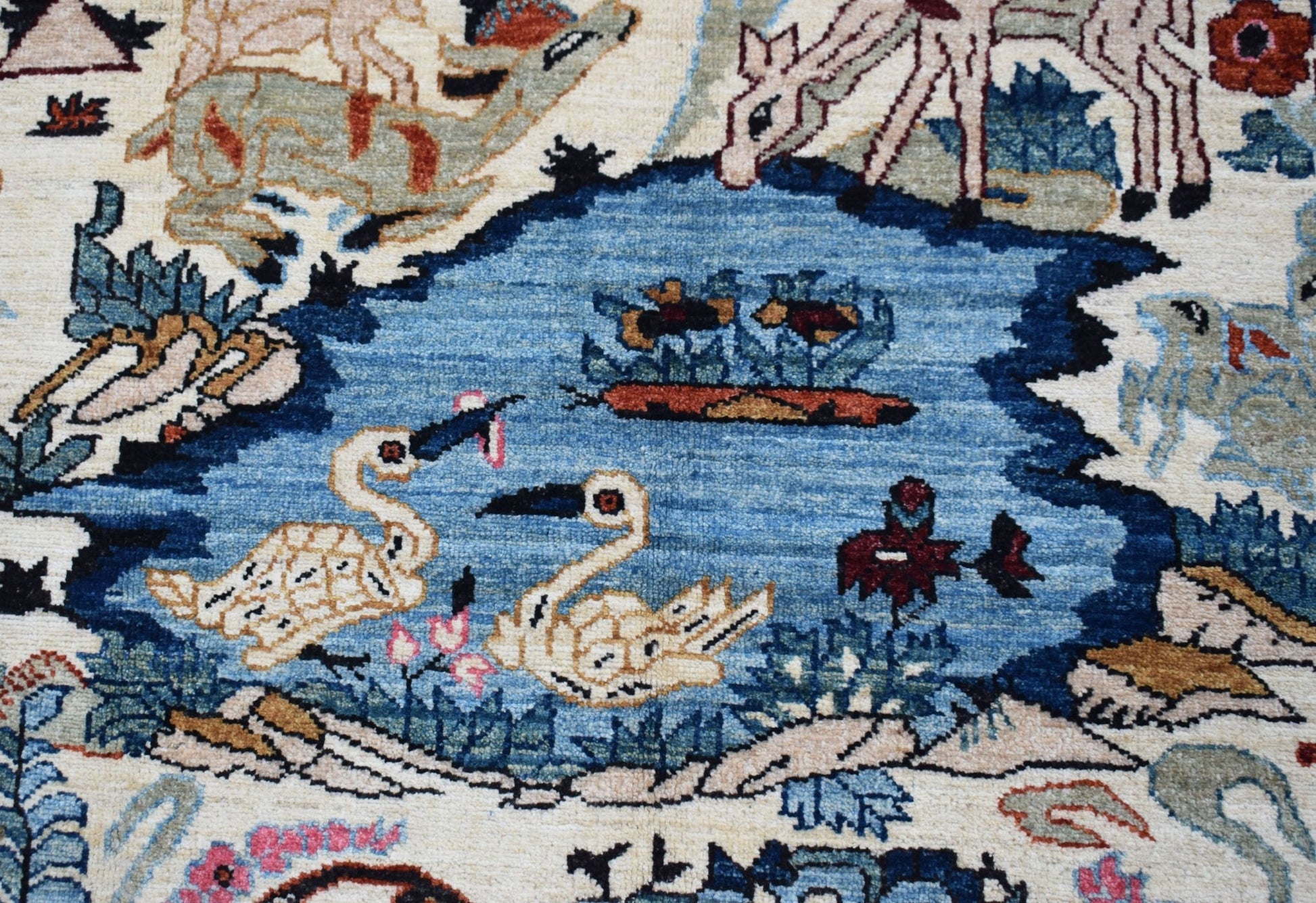 A handwoven Afghan Chobi rug featuring a detailed hunting scene with animals and birds.