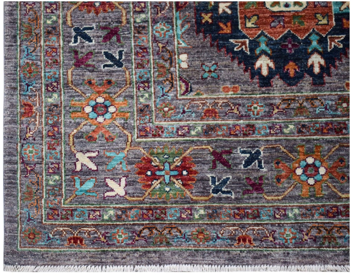 A handwoven Afghan Chobi rug featuring a grey field with intricate floral and geometric patterns.