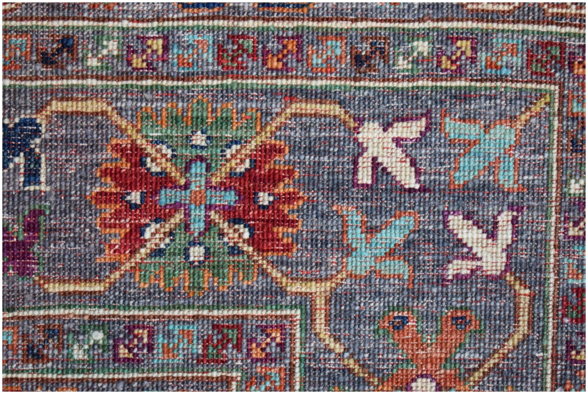 A close-up of a handwoven Afghan Chobi rug featuring intricate floral patterns in earthy tones.