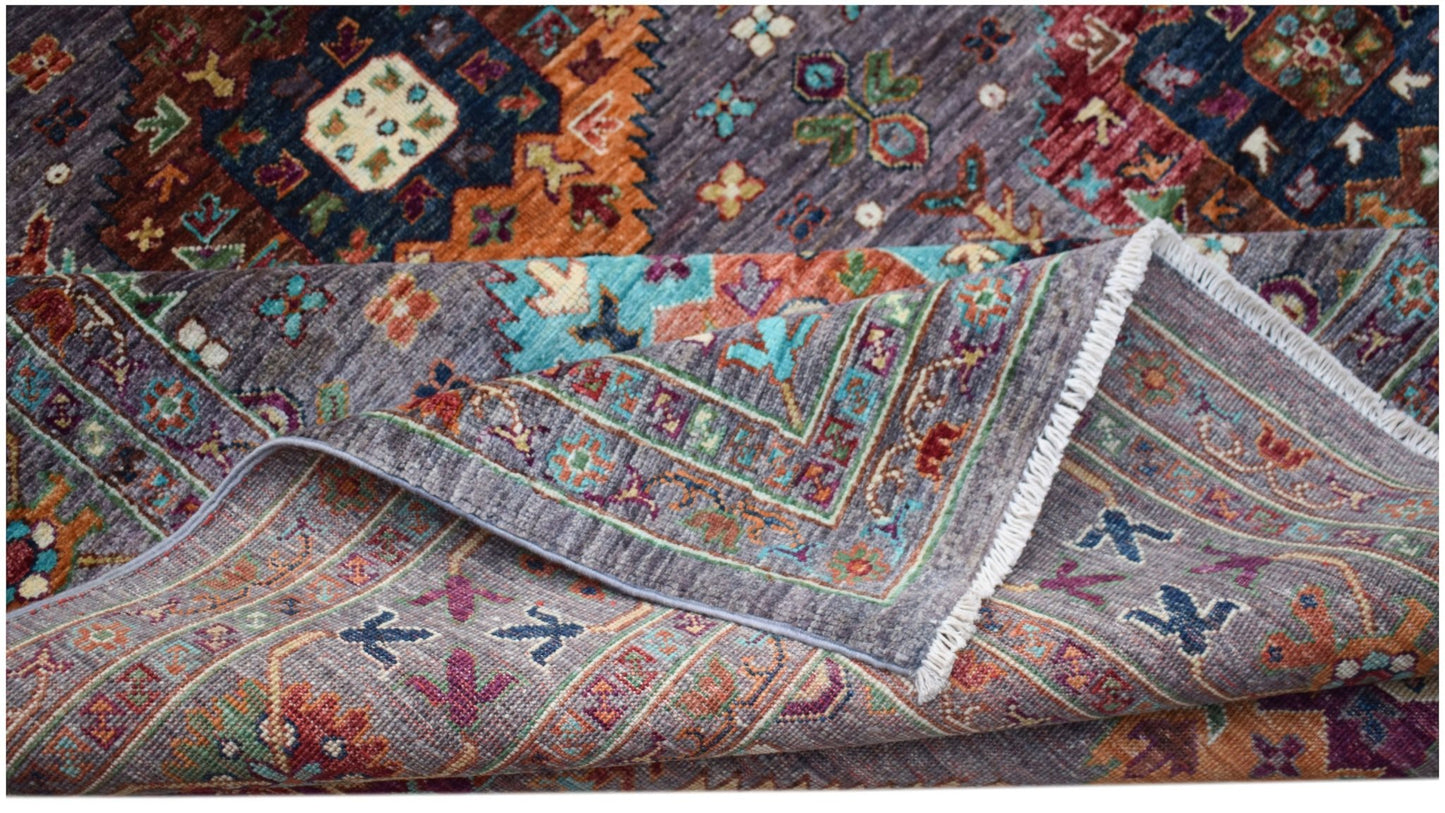 A handwoven Afghan Chobi rug featuring intricate geometric patterns in vibrant, earthy tones.