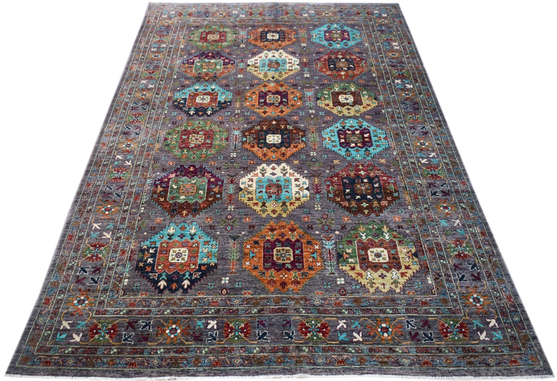 A handwoven Afghan Chobi rug featuring a grey field with colorful geometric medallions.