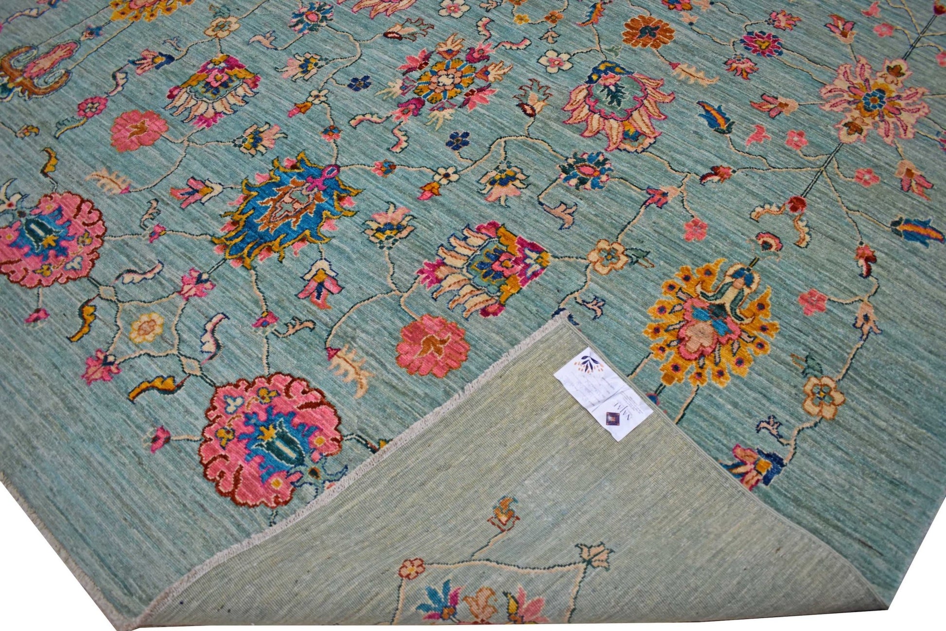 A handwoven Afghan Chobi rug featuring a floral pattern in vibrant colors on a light blue field.