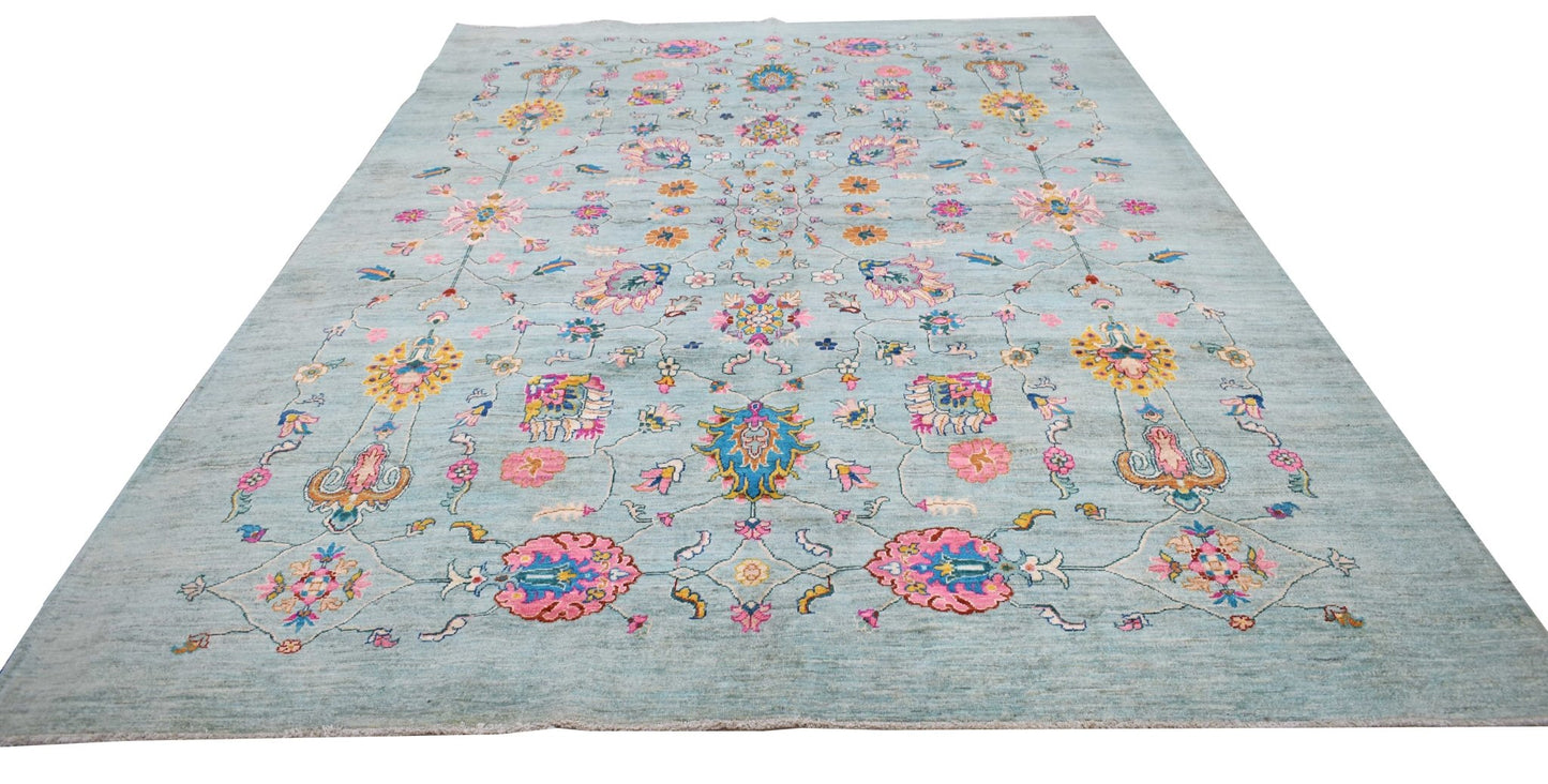 A handwoven Afghan Chobi rug featuring a light blue field with colorful floral and vine patterns.