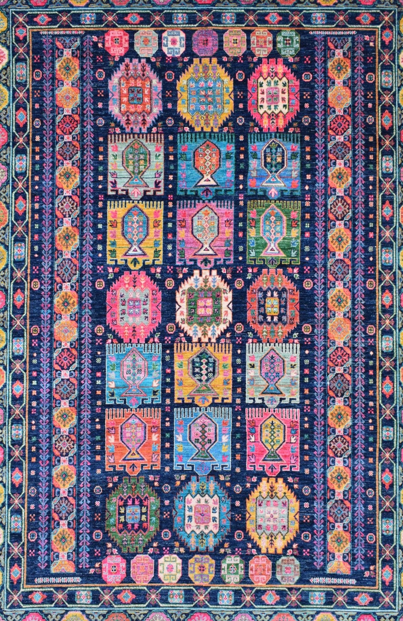 A rectangular Afghan Chobi rug featuring a dark blue field with colorful geometric motifs.