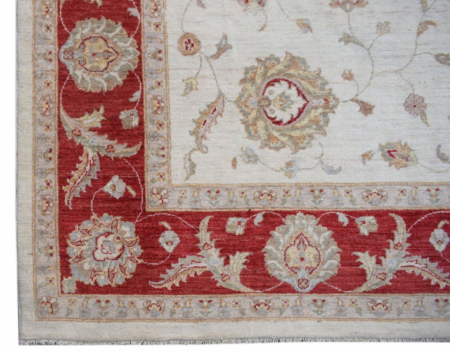 A handmade Afghan Chobi rug featuring a cream field with floral motifs and a red border.