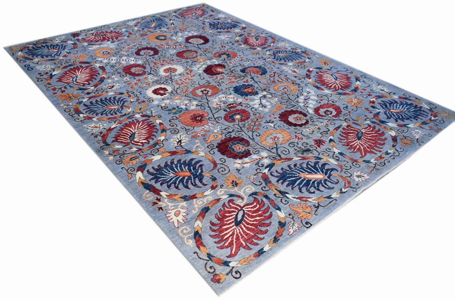 An Afghan Chobi rug featuring a traditional floral pattern in red and blue on a light blue field.