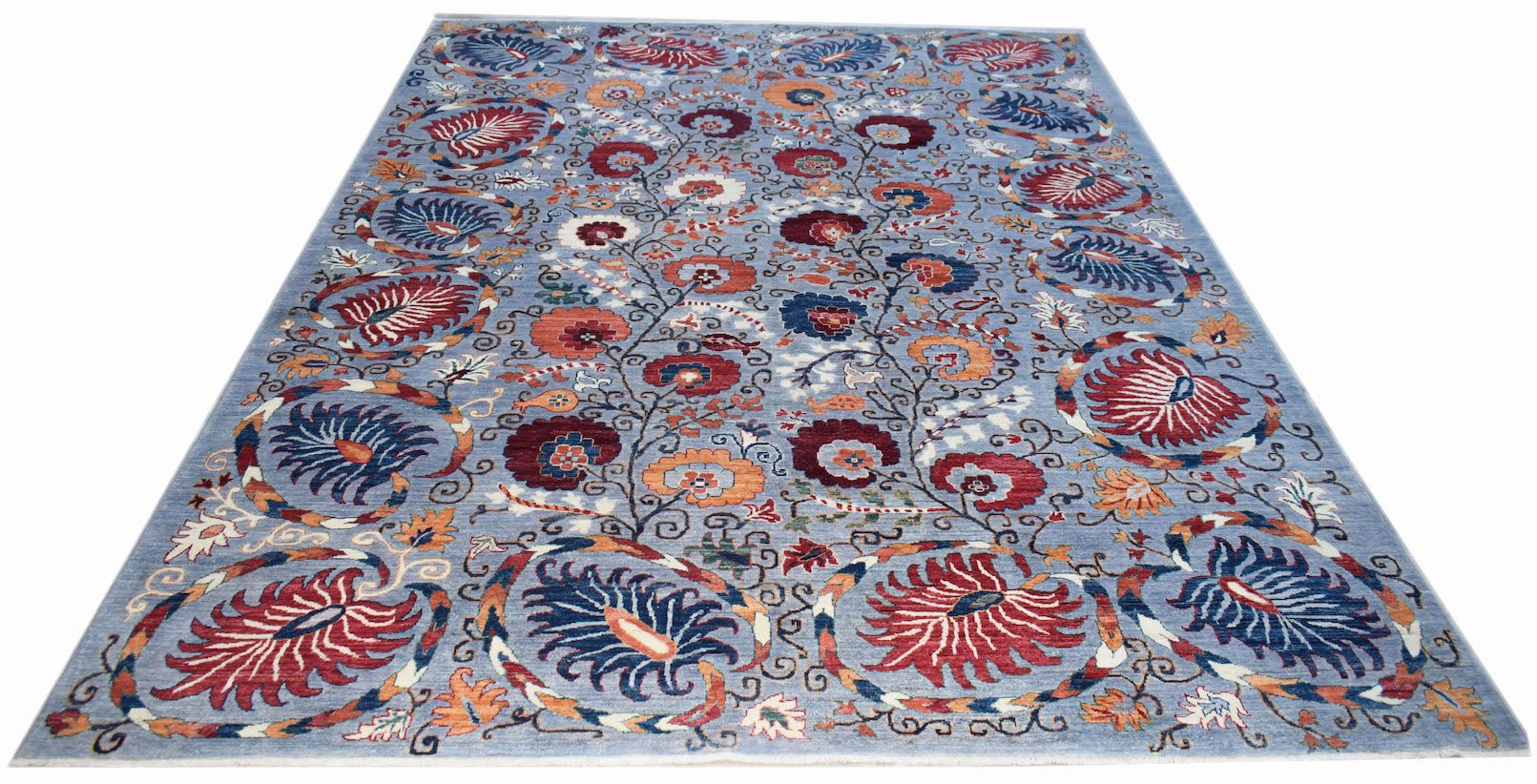An Afghan Chobi rug featuring a traditional floral pattern in red and blue on a light blue field.