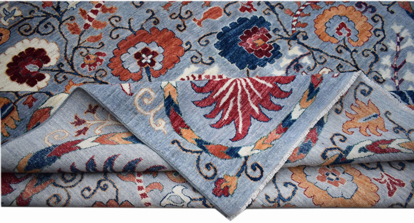 A handwoven Afghan Chobi rug featuring a floral pattern in blue, red, and orange tones.