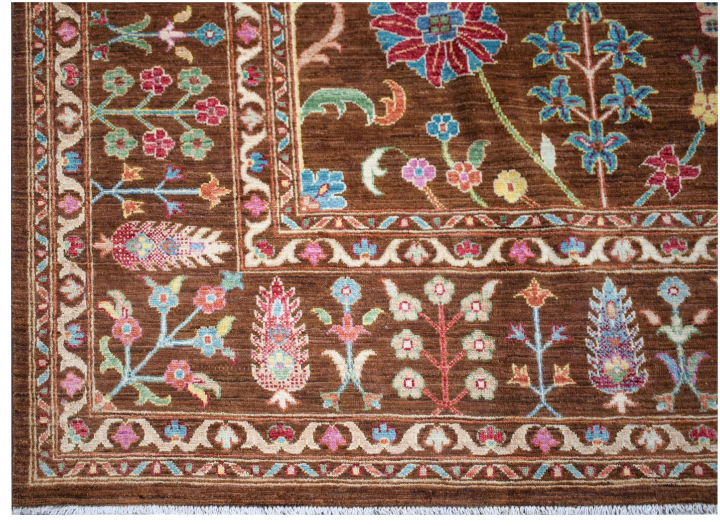 A handwoven Afghan Chobi rug featuring a brown field with intricate floral and botanical patterns.