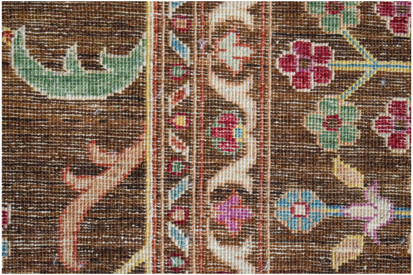 A close-up of a handwoven Afghan Chobi rug featuring intricate floral patterns in earthy tones.