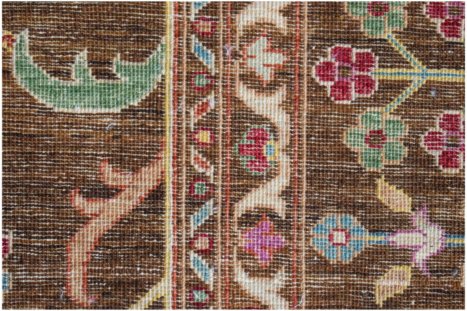 A close-up of a handwoven Afghan Chobi rug featuring intricate floral patterns in earthy tones.