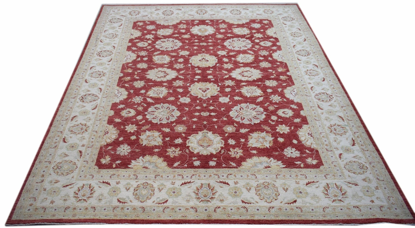A rectangular Afghan Chobi rug featuring a red field with intricate floral patterns and a cream border.