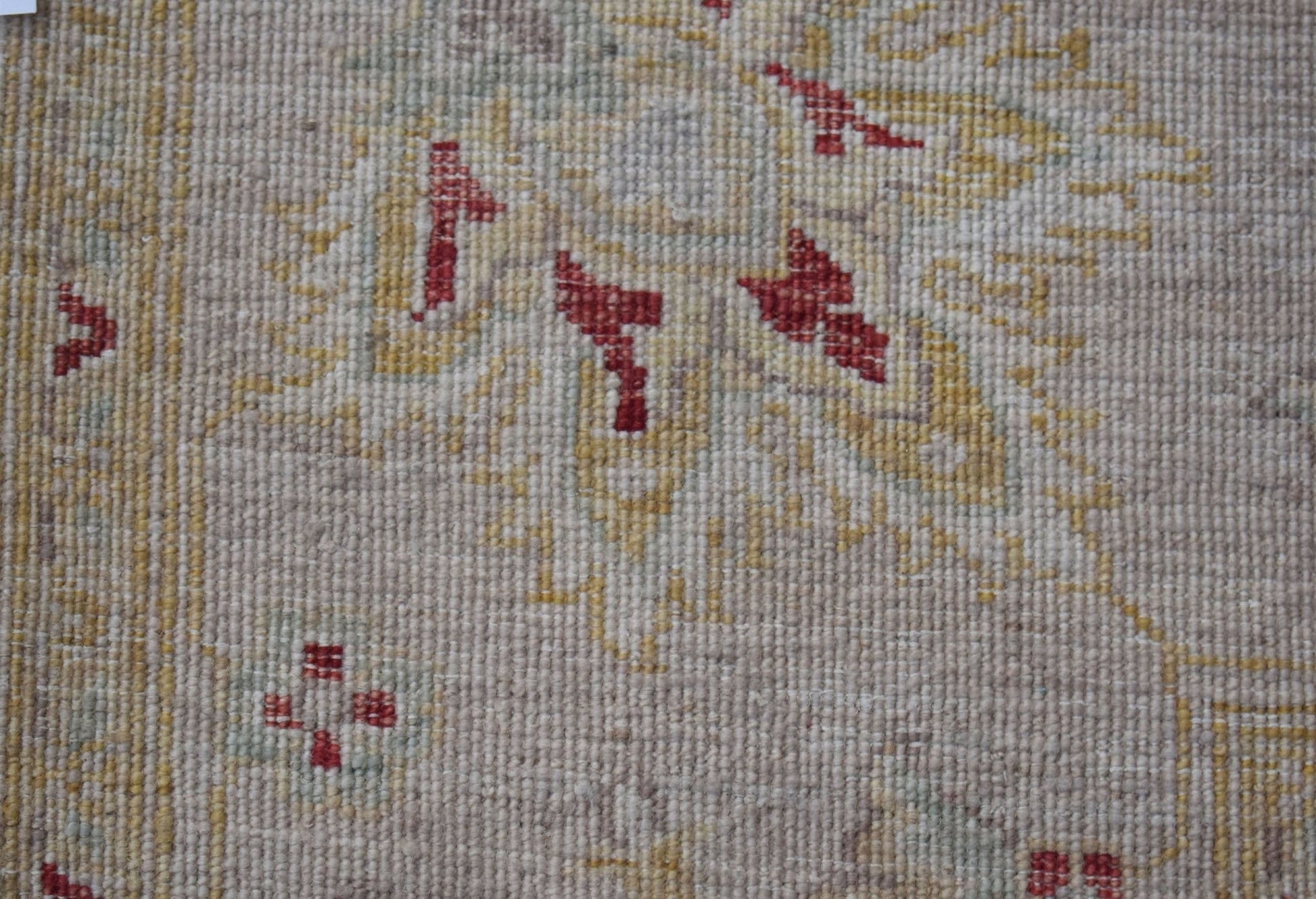 A close-up of a handwoven Afghan Chobi rug featuring traditional geometric patterns in red and gold.