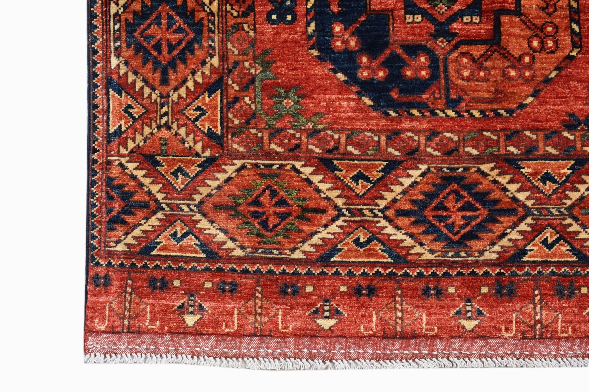 A handmade Afghan Chobi rug featuring traditional geometric patterns in red, blue, and cream.