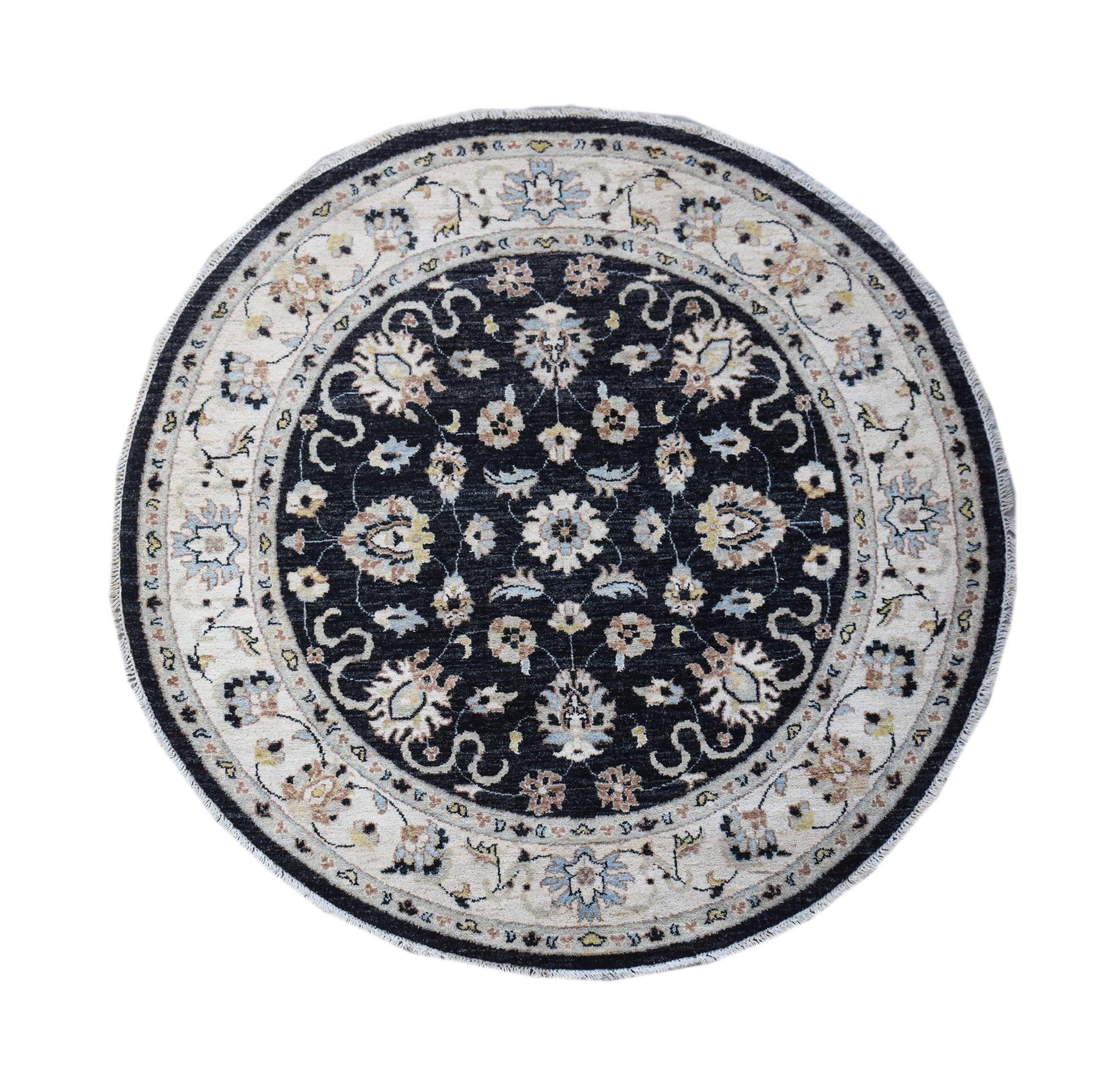 A round Afghan Chobi rug featuring a dark central medallion with intricate floral patterns.