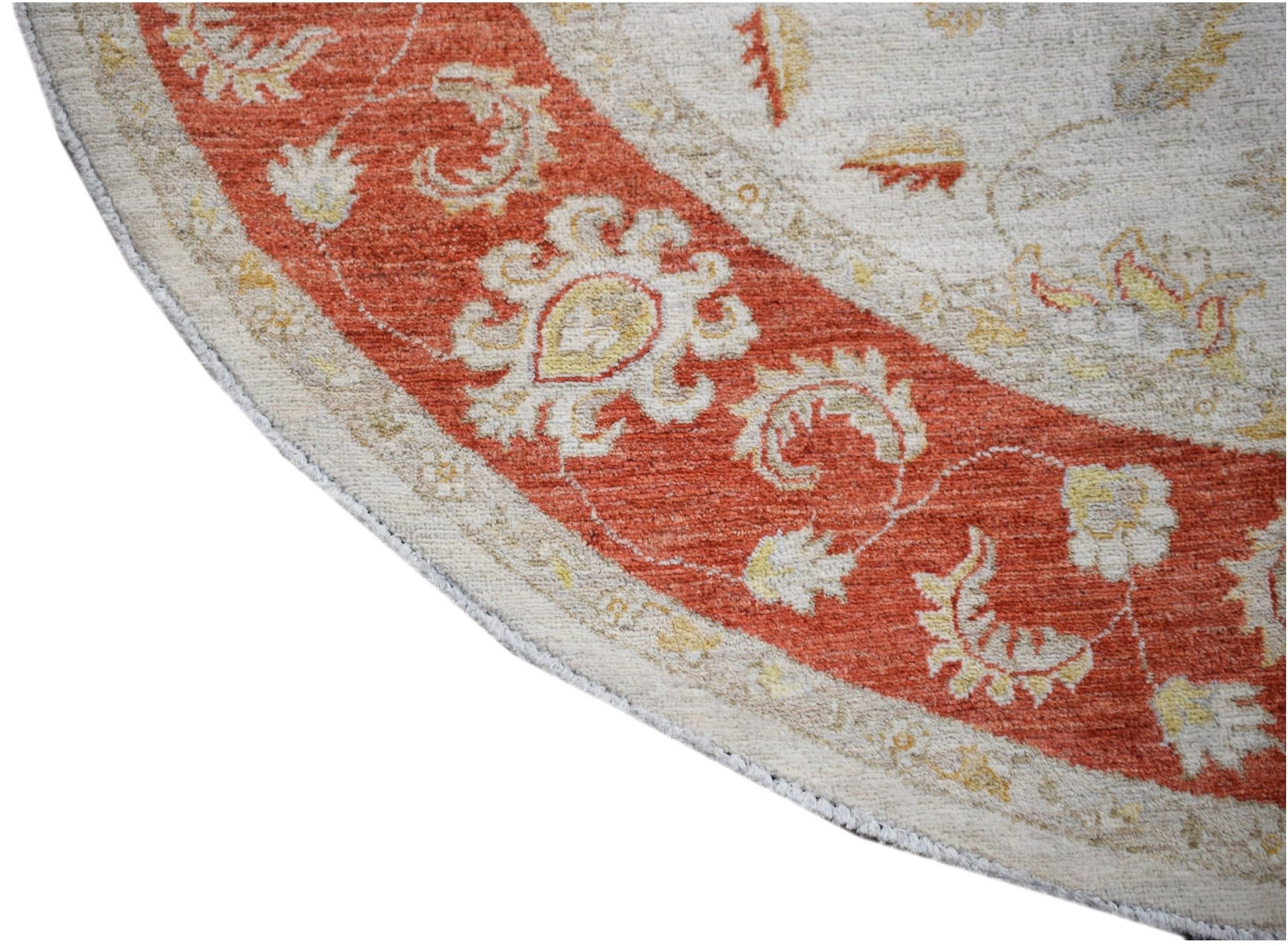 A round Afghan Chobi rug featuring a terracotta border with intricate floral patterns.