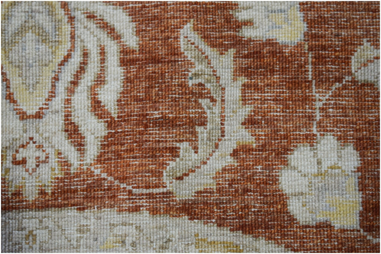 A close-up of a handwoven Afghan Chobi rug featuring intricate floral patterns in earthy tones.