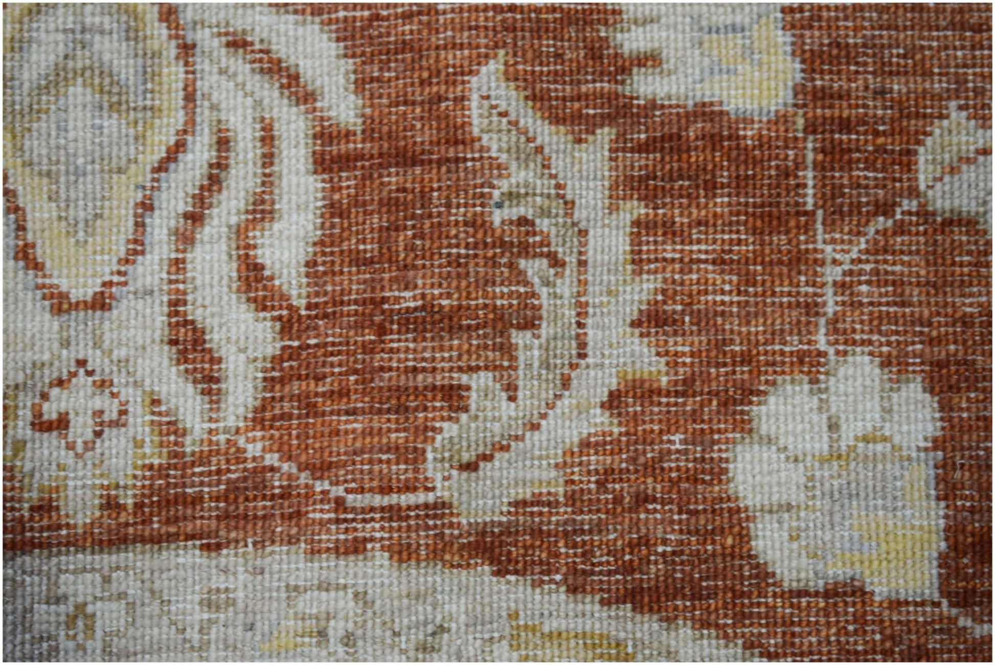 A close-up of a handwoven Afghan Chobi rug featuring intricate floral patterns in earthy tones.