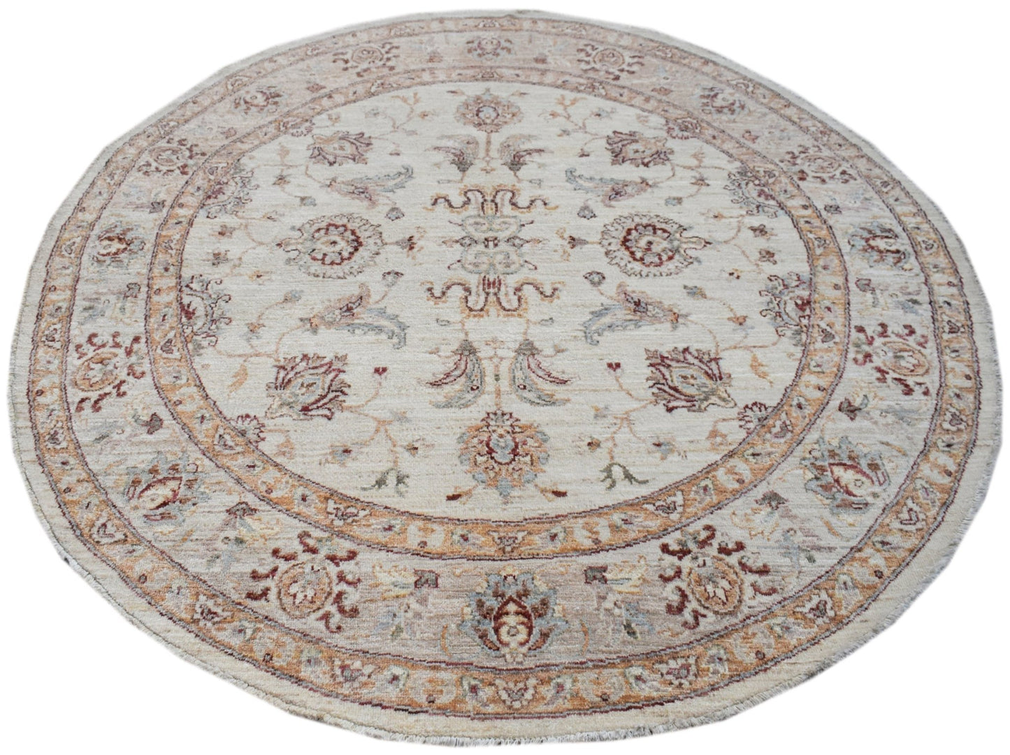 A round, handwoven Afghan Chobi rug featuring a traditional floral pattern in soft, earthy tones.