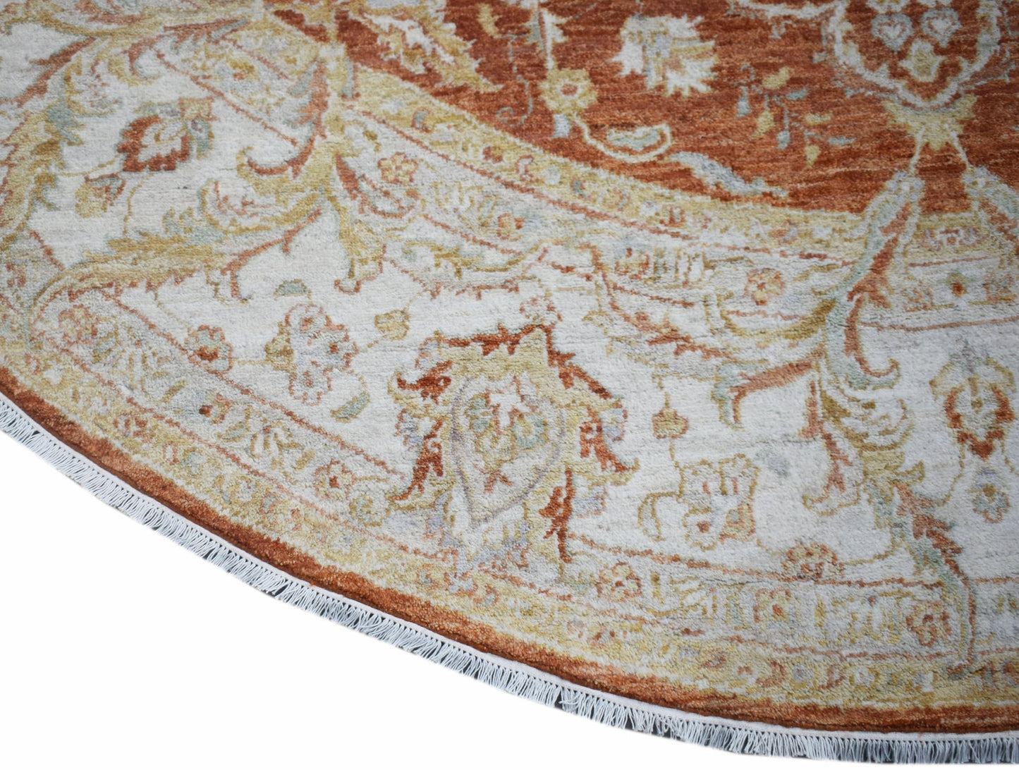 A round Afghan Chobi rug featuring intricate floral patterns in earthy tones with a fringed edge.