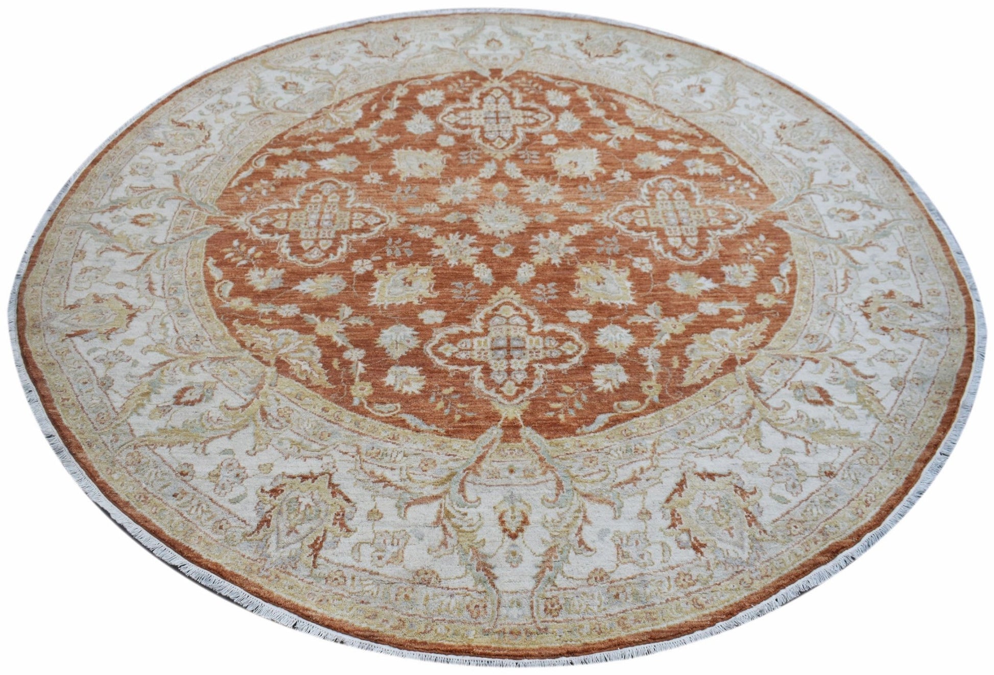A round Afghan Chobi rug featuring a rust-orange center with intricate floral patterns.