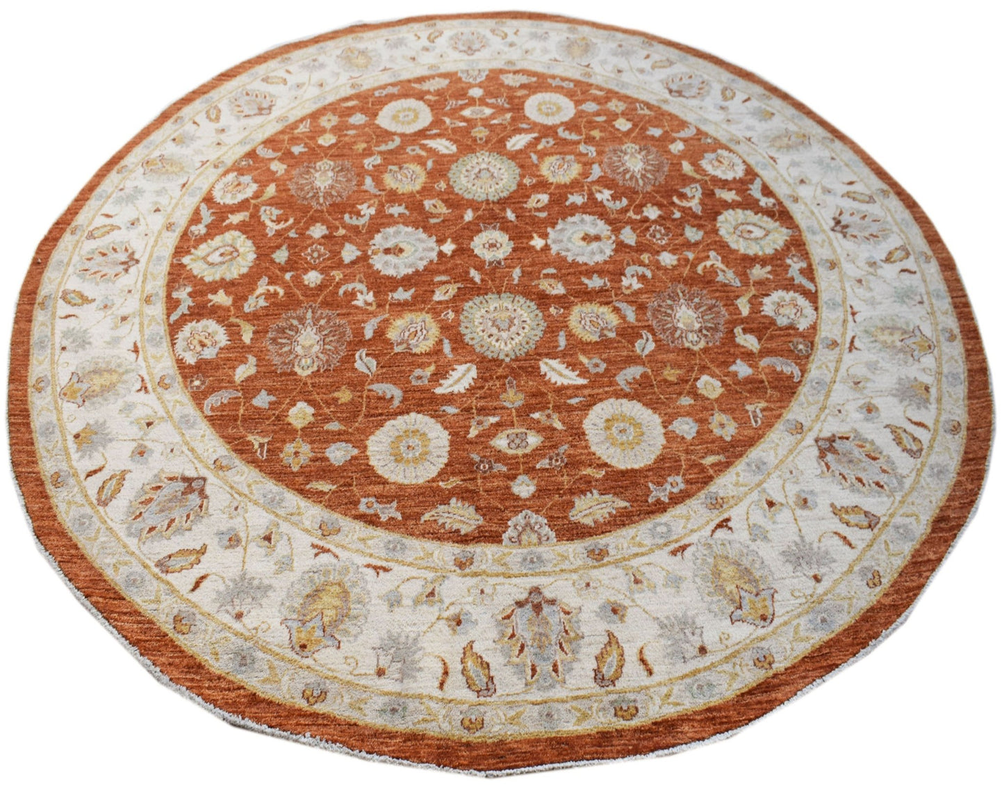 A round, handwoven Afghan Chobi rug featuring a traditional floral pattern in rust and cream tones.