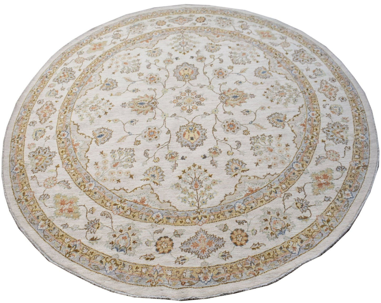 A round Afghan Chobi rug featuring a traditional floral pattern in soft, earthy tones.